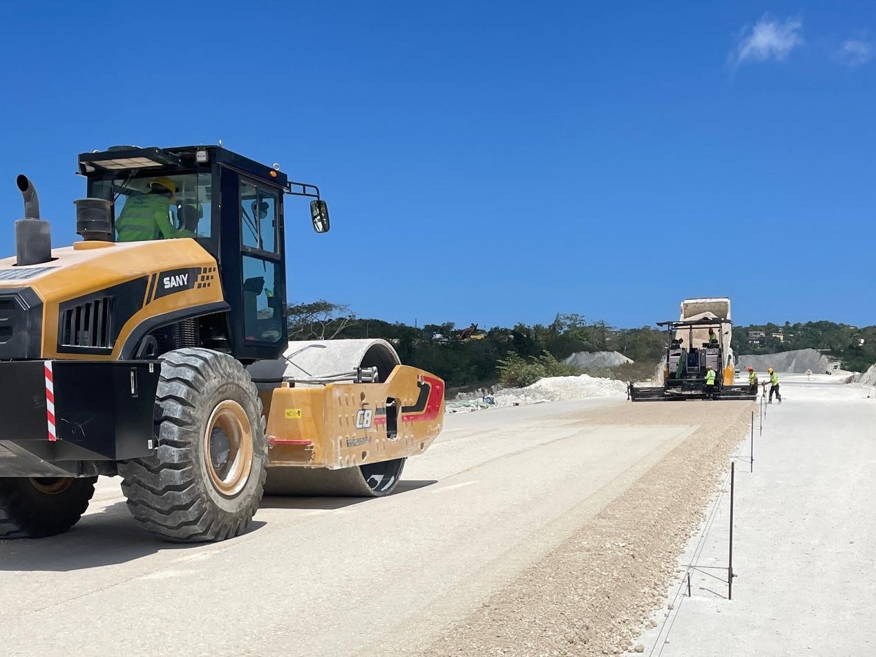 圖為中企承建的牙買加蒙特哥貝繞城路項目基層試驗段正在進行攤鋪和碾壓施工，相關施工工作已于日前順利完成。中國港灣美洲區(qū)域公司供圖