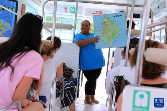 3月15日，一名導(dǎo)游在游艇上為游客介紹塞舌爾拉迪格島。新華社記者 董江輝 攝