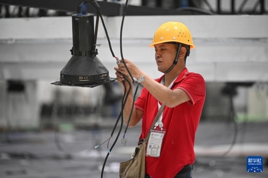 4月4日，工作人員在海南國(guó)際會(huì)展中心內(nèi)布設(shè)燈光。