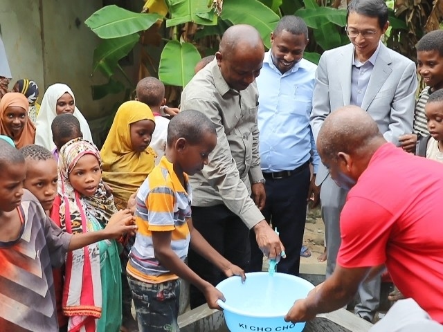 在日前舉行的安全供水工程揭牌儀式上，當(dāng)?shù)匦∨笥言诠┧c(diǎn)接水。 施亮攝