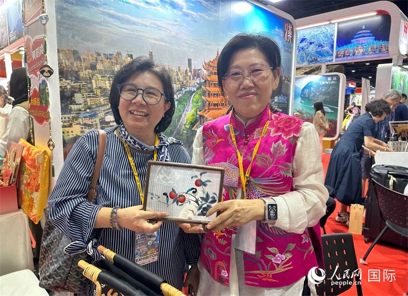 中國“大冶刺繡”傳承人劉小紅（右）參加泰國國際旅游展，向觀眾介紹中國非遺刺繡針法。人民網(wǎng)記者 簡承淵攝