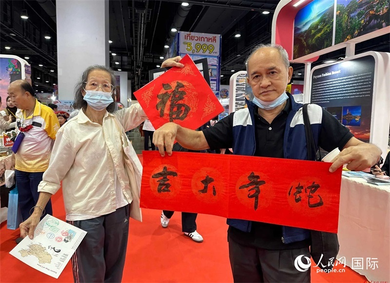 2025蛇年春節(jié)，泰國市民展示他們領(lǐng)到的華人手寫春聯(lián)。人民網(wǎng)記者 簡承淵攝