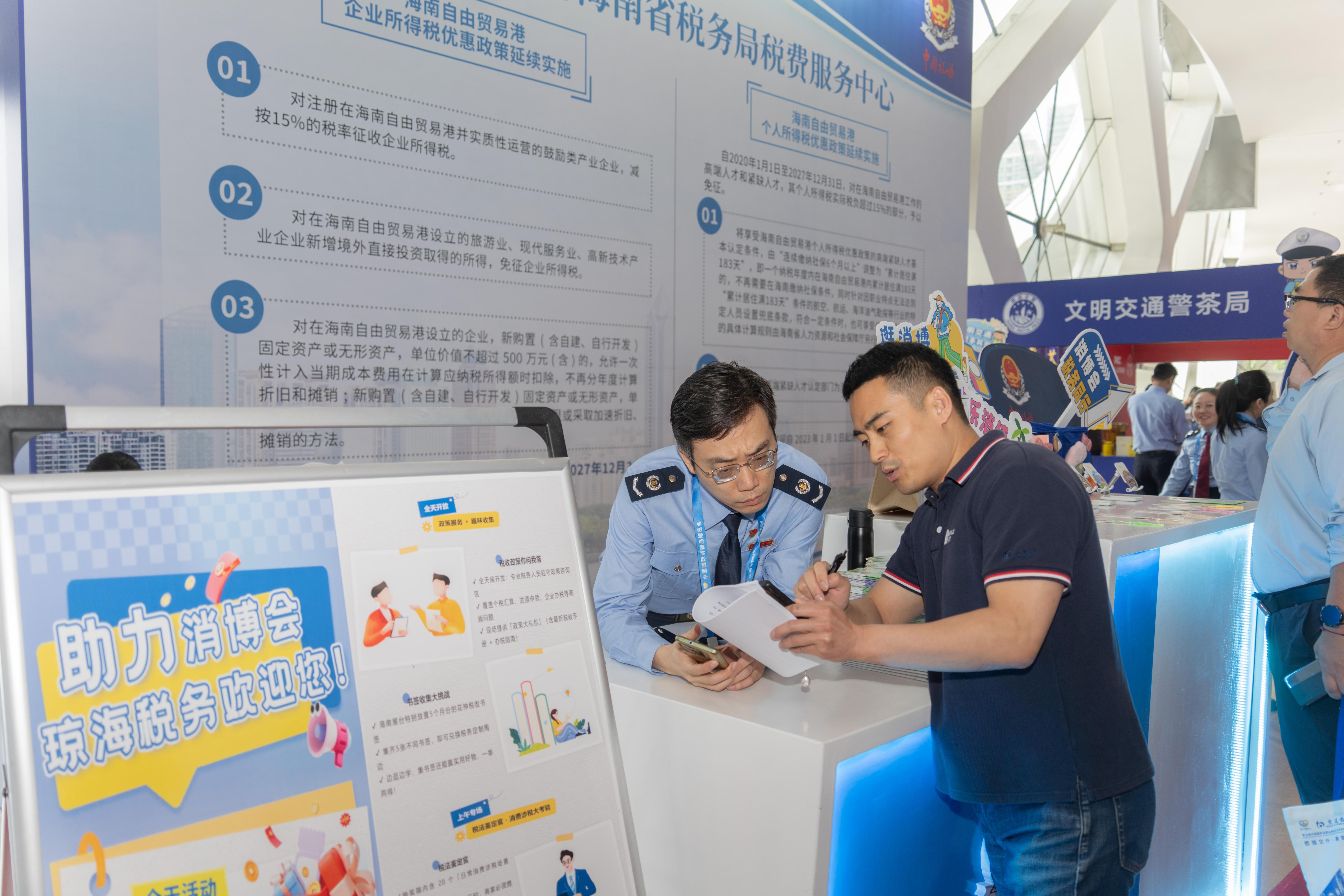 稅務(wù)服務(wù)臺工作人員向記者介紹服務(wù)參展外商的具體舉措。人民網(wǎng)記者 許崢攝