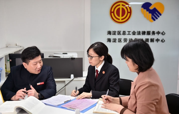 2025年3月6日，在北京市海淀區(qū)總工會勞動爭議調(diào)解中心，海淀區(qū)人民法院法官王琰（中）與該中心工作人員就糾紛化解情況進行溝通。新華社記者 趙婷婷 攝