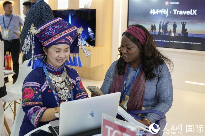 來自廣西的旅游業(yè)者同客戶交流。人民網(wǎng)塔里克·易卜拉欣攝