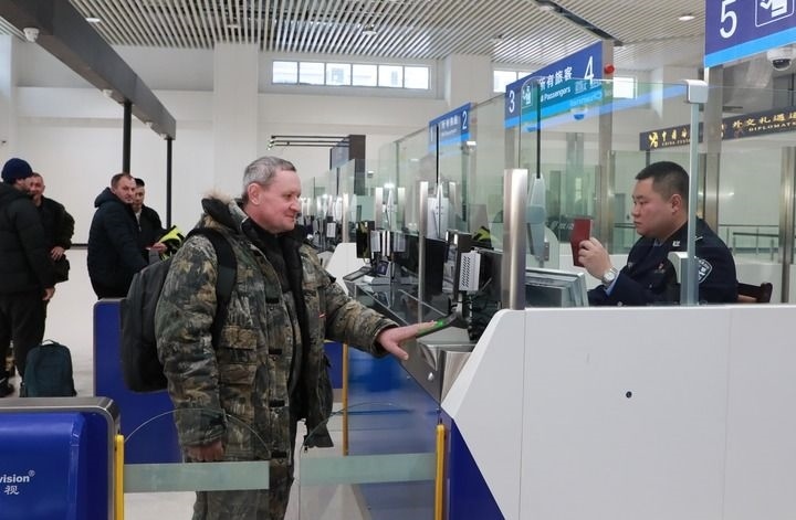 2024年12月10日，在黑河公路口岸旅檢大廳，黑河出入境邊防檢查站民警為首班次客車入境旅客辦理邊檢通關(guān)手續(xù)。當(dāng)日，中國黑河公路口岸—俄羅斯卡尼庫爾干公路口岸旅客運輸正式開通。新華社發(fā)（劉松攝）