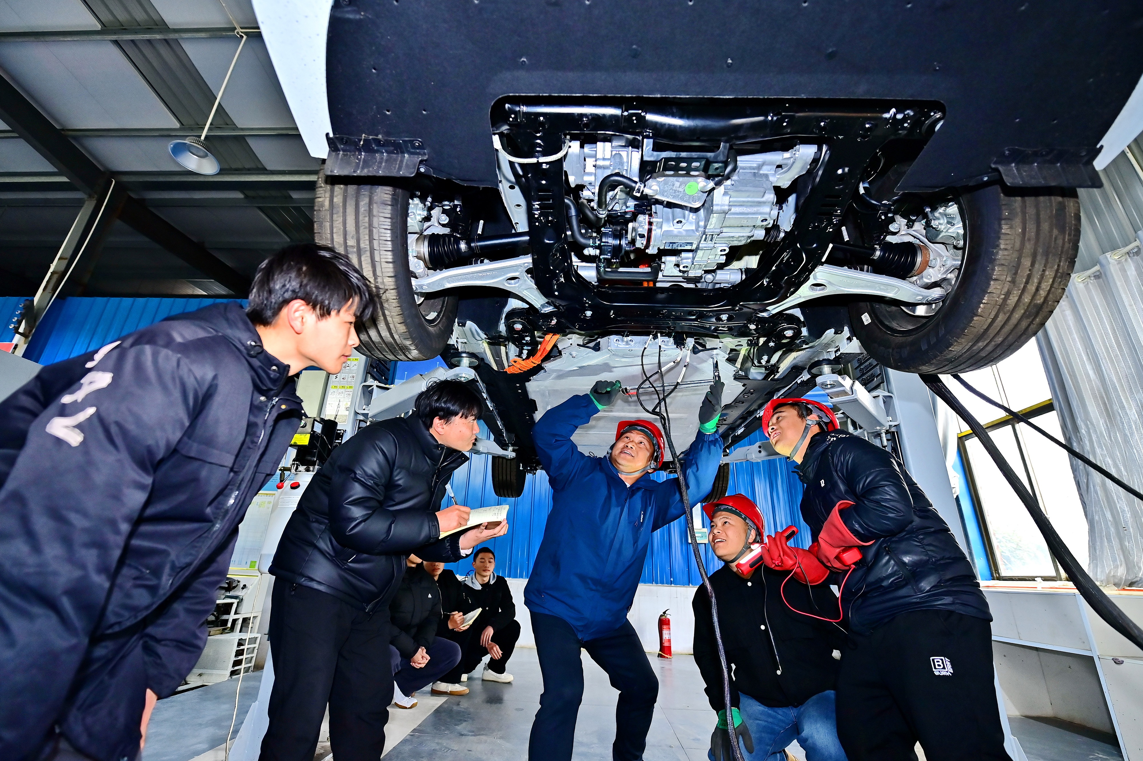 2025年2月，江西省宜春市，豐城市的一所技工學(xué)校實(shí)訓(xùn)基地內(nèi)，新能源汽車運(yùn)維專業(yè)學(xué)生在老師的指導(dǎo)下學(xué)習(xí)新能源汽車電池包檢修技術(shù)。