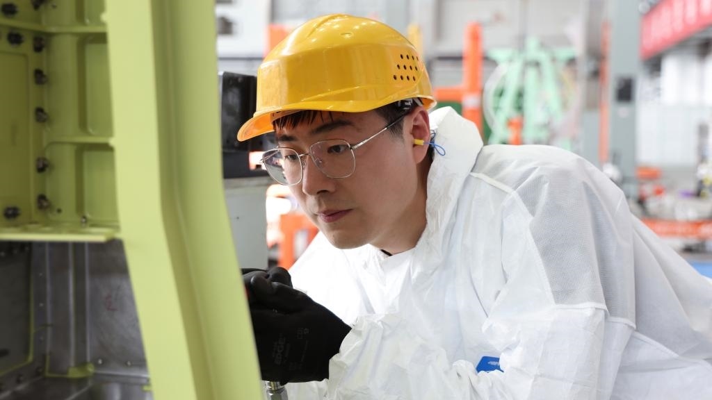 在中國(guó)航空工業(yè)集團(tuán)成飛車(chē)間內(nèi)，飛機(jī)鉚裝鉗工首席操作技師馮攀龍正在工作。（新華社發(fā)）