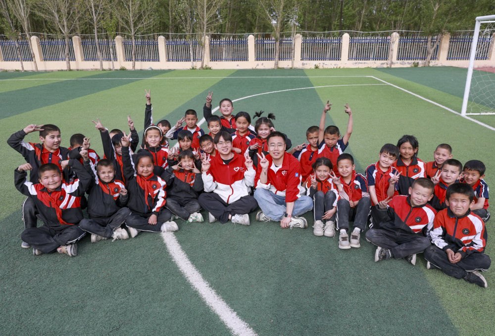 4月23日，在新疆克州阿圖什市哈拉峻鄉(xiāng)謝依特小學，支教教師王俊文（中左）、李軻凡（中右）和學生在一起。