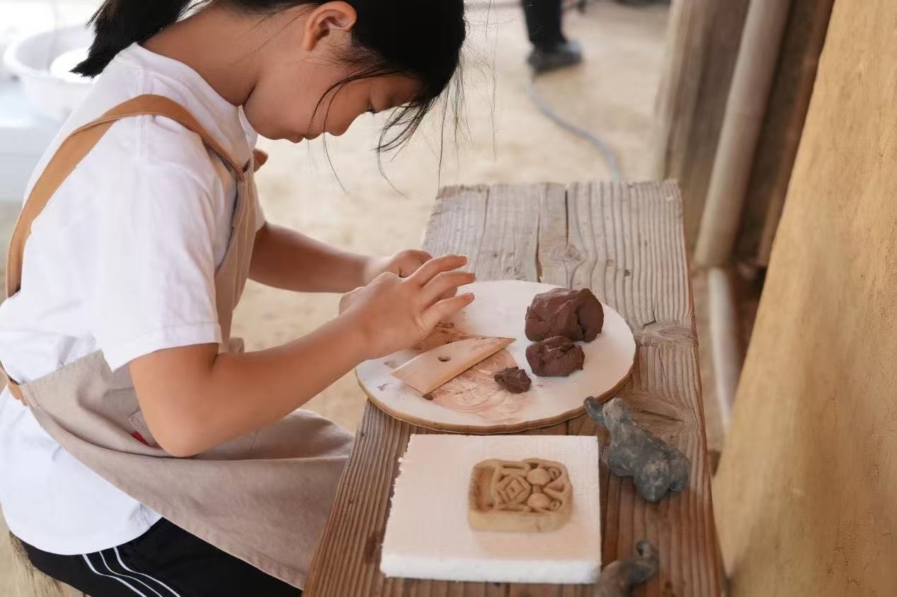游客制作良渚特色陶藝品。良渚博物院供圖