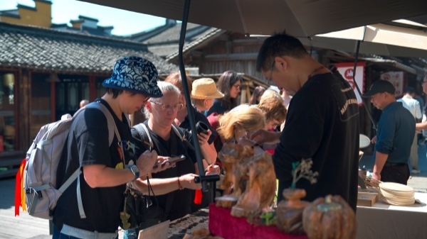 “五一”期間，游客正在烏鎮(zhèn)“水鄉(xiāng)碼頭”挑選購買文創(chuàng)產(chǎn)品。受訪者供圖