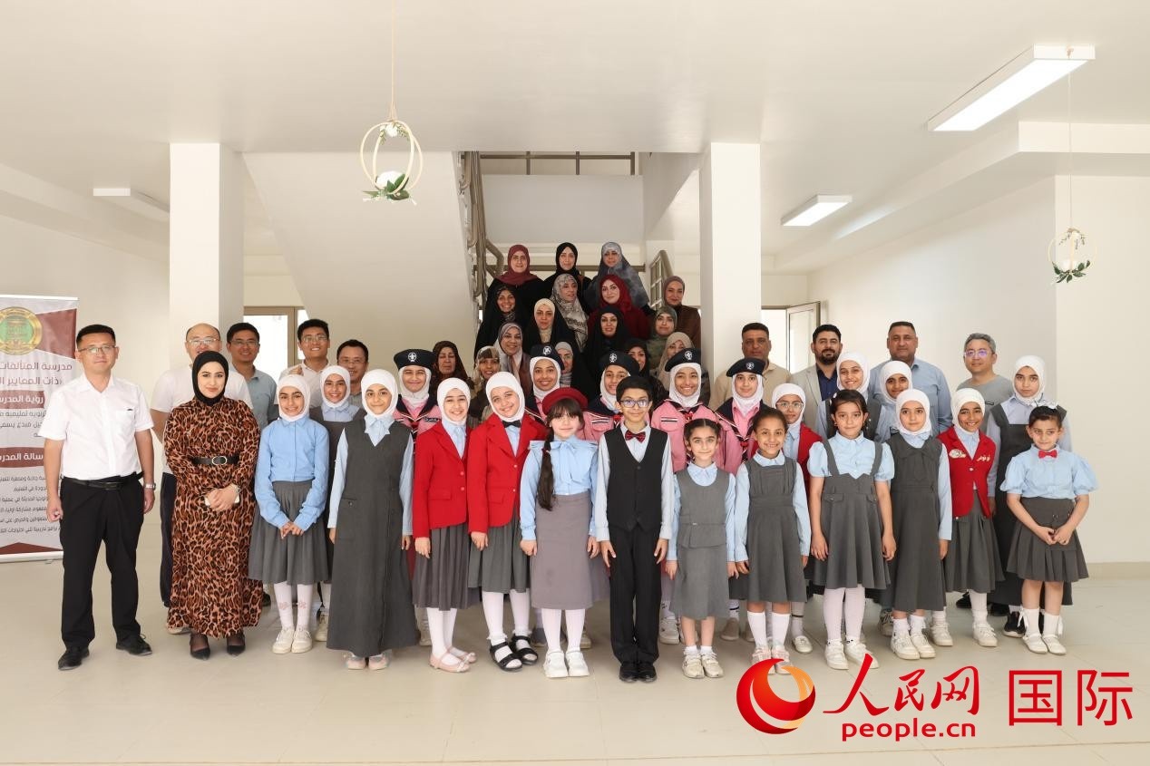 中國電建員工與阿爾穆塔?阿里卡特國際學校的師生及政府官員等合影。人民網(wǎng)記者 薛丹攝