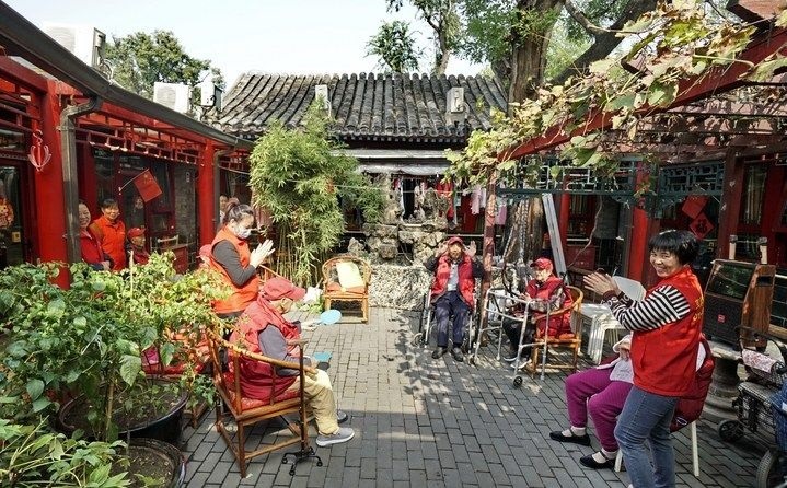 2024年10月12日，鐘樓灣胡同的老年人在社區(qū)內(nèi)的四合院養(yǎng)老驛站休閑。2017年起，北京市先后開展了兩輪背街小巷環(huán)境整治提升行動，完整保留了中軸線生活建筑群的歷史信息，并根據(jù)居民的生活和居住方式進行適配化的更新和改造，極大地改善了生活環(huán)境。2023年鐘樓灣胡同被評為“北京最美街巷”。