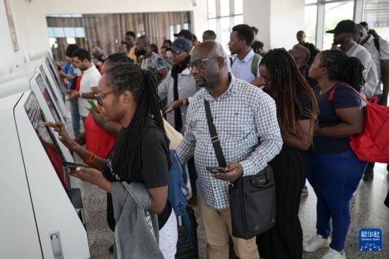 5月31日，在蒙內(nèi)鐵路內(nèi)羅畢站，乘客在自助取票機(jī)前排隊(duì)取票。新華社記者 楊光 攝