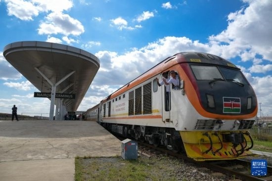 5月31日，在蒙內(nèi)鐵路內(nèi)羅畢站，機(jī)車駕駛員蔣立平（右）和博爾在即將開往蒙巴薩的E2次列車上揮手致意。新華社記者 楊光 攝