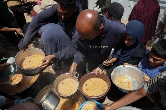 5月28日，人們?cè)诩由吵俏鞑康纳程犭y民營(yíng)領(lǐng)取救助食物。新華社發(fā)（里澤克·阿卜杜勒賈瓦德攝）